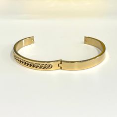 Bring home this magnificent bangle bracelet. Featuring a polished curb chain inlay design this bracelet is made from stainless steel. This is a seriously pretty bangle that is easy way to dress up any outfit, it makes a beautiful gift or a special treat for yourself.- Metal: Stainless Steel.- Plating: 18k Gold plated.- Inner Diameter: 64 mm.- Width: Aprox. 8 mm.- Clasp: Snap Closure.- Circumference Inches: 7.85 Ships in a Balara Gift Pouch.Available in Gold.SKU# B1781 Elegant Metal Cuban Link Bracelet With Curb Chain, Elegant Adjustable Cuban Link Metal Bracelet, Elegant Cuban Link Metal Bracelets, Trendy Cuban Link Bracelets For Gift, Elegant Adjustable Gold Bracelet With Curb Chain, Gold Stainless Steel Bracelets With Curb Chain, Gold Stainless Steel Bracelet With Curb Chain, Trendy Tarnish Resistant Cuff Bracelet Bangle, Elegant Curb Chain Bangle