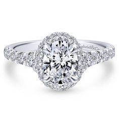 a diamond engagement ring with an oval center surrounded by round diamonds