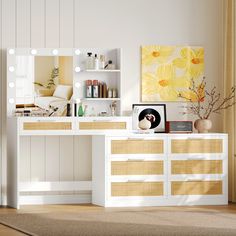 a white vanity with drawers and lights in a room that has a painting on the wall