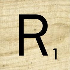 the letter r is written in black on a wooden surface with an arrow pointing to it