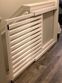 a white radiator sitting on top of a hard wood floor next to a wall