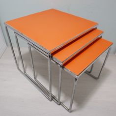 three orange tables stacked on top of each other