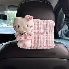 a hello kitty stuffed animal in the back seat of a car