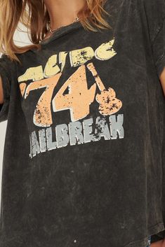 Mineral washed graphic t-shirt Vintage-style "AC/DC '74 Jailbreak" text graphic print. Round neckline. Short sleeves. Drop shoulder. Relaxed fit. 100% Cotton. Imported top designed and printed in Los Angeles, CA. Officially licensed AC/DC merchandise. Not eligible for discounts. Model wears size S. Text Graphic, Iron Decor, Charcoal Color, Ac Dc, Drop Shoulder, Round Neckline, Graphic Prints, Graphic T Shirt, Tops Designs