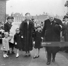 an old black and white photo shows people walking down the street with their children in tow