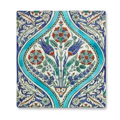 an intricately decorated tile with blue and red flowers on it's sides, against a white background