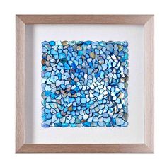 a blue and white mosaic tile in a wooden frame on a white wall with a light wood frame