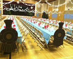 a large banquet hall with long tables and blue tablecloths on the tables are decorated with red and white decorations