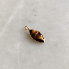 ITEM DESCRIPTION: >>The pendant is made from Solid 14K Yellow Gold. Gemstone used is absolutely natural and ethically sourced. >>Natural Tiger Eye in cabochon marquise shape with bezel setting is studded on it with utmost precision. >>This is a minimalist design and is absolutely hassle-free and everyday jewelry. Gem: Tiger Eye Gem size: 11x21 mm Marquise Gem weight: 9.55 carats Gold purity: 14K (58.33% approx.) Gold weight: 0.56 grams Gross weight: 2.46 grams The Gold purity is guaranteed and i Gold Cabochon Teardrop Pendant Jewelry, Gold Cabochon Teardrop Pendant, 14k Gold Amber Jewelry With Polished Finish, Polished 14k Gold Amber Jewelry, Gold Pendant Gemstones As A Gift, Gold Pendant Gemstones For Gift, Fine Jewelry Gemstone Pendant For Gift, Gold-colored Polished Sterling Silver Gemstones, Gold Polished Sterling Silver Gemstones