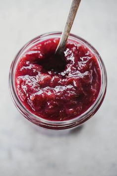 a spoon sticking out of a jar filled with jam