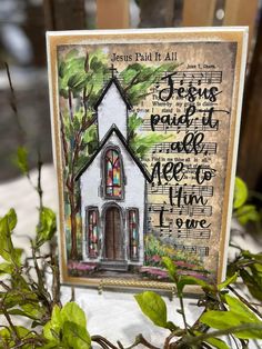 a card with an image of a church surrounded by greenery and words that read jesus paid it all