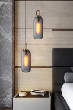 two lights hanging from the ceiling above a bed