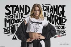 a woman standing in front of a wall with words on it and wearing a crop top