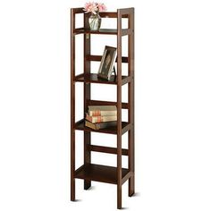 a wooden shelf with books on top of it and a vase filled with flowers next to it