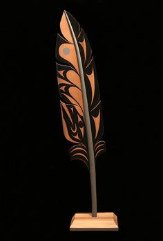 a decorative metal object on a wooden stand in the dark, with a black background