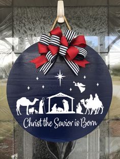 a christmas ornament hanging on a door with the nativity scene painted on it