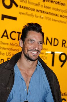 a smiling man in front of a yellow sign with the words actnd radio on it