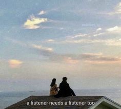 two people sitting on top of a roof with the ocean in the background and sky above them