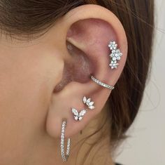 a close up of a person's ear with three different types of piercings