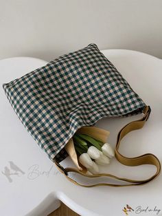 a bouquet of tulips wrapped in a green and white checkered fabric on a chair