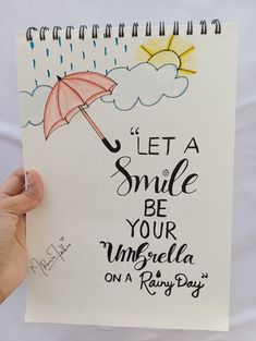 a hand holding up a note with an umbrella on it that says let a smile be your umbrella on a rainy day