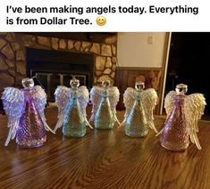 five glass angel figurines sitting on top of a table next to a fireplace