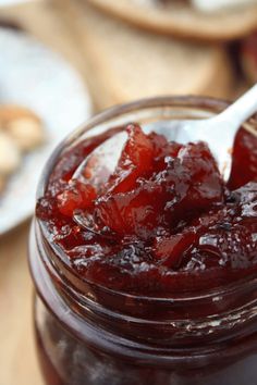 a glass jar filled with cranberry sauce on top of a red and white cloth