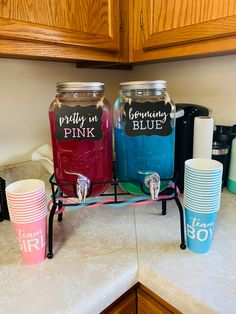 three mason jars with pink, blue and green lids sitting on a kitchen counter