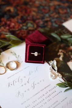 wedding rings and ring box sitting on top of an envelope