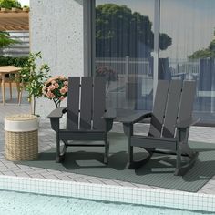 two chairs and a table sitting next to a swimming pool