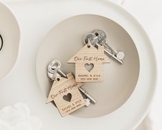 two wooden house keychains sitting on top of a white plate