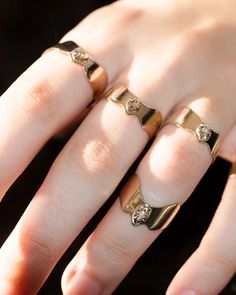 two gold rings with diamonds on their fingers