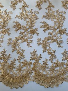 Melody GOLD Polyester Floral Embroidery with Sequins on Mesh Lace Fabric by the Yard for Gown, Wedding, Bridesmaid, Prom - 10002 Stand out magnificently as you gracefully appear wearing this stunning flowing fabric. Intricate embroidery adorns this fabric, with some sequins scattered all throughout, giving it a lavish and regal feel. Content: 100% polyester Stretch: Minimal to none Width: 50 to 52 inches Edge: Scalloped on both edges Uses: Wedding dress, evening gown, formal wear, tops, skirts, Lace Vail, Gold Lace Gown, Gold Lace Fabric, Embroidery With Sequins, Embroidery Tshirt, Embroidery Shoes, Gowns For Girls, Lace Curtains, Linens And Lace