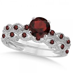 a ring with red stones on top and white diamonds around the band, set in silver