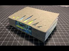 a stack of notebooks sitting on top of a black table next to a knife