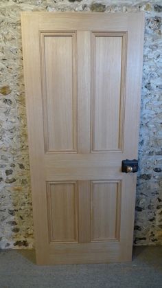 a wooden door in front of a stone wall