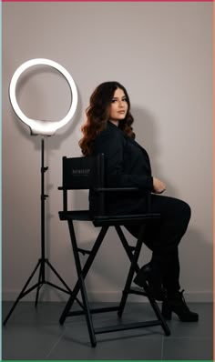 a woman sitting in a chair with a light behind her