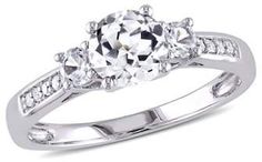 a white gold ring with three stones on the side and an oval center stone in the middle