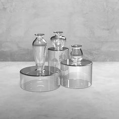 three glass vases are sitting on top of each other in this black and white photo