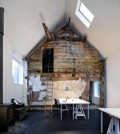 an unfinished room with a ladder leaning up against the wall and windows on the roof