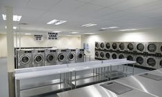 a row of washers and dryers in a laundry room