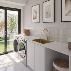 a washer and dryer in a room with pictures on the wall