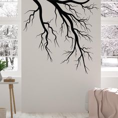 a tree branch with no leaves is shown in the corner of this room, and it's branches are black