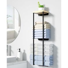 a bathroom shelf with towels and a mirror