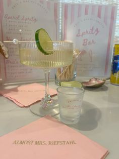 a table topped with two glasses filled with liquid and lime wedged in the middle