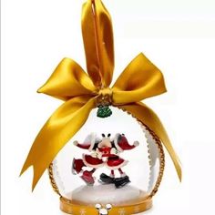 a glass ornament with a gold ribbon and santa clause on it's head