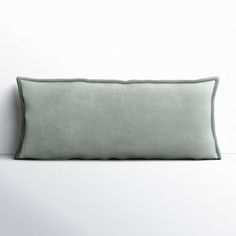 a green pillow sitting on top of a white wall