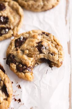 chocolate chip cookies on parchment paper with one broken in half