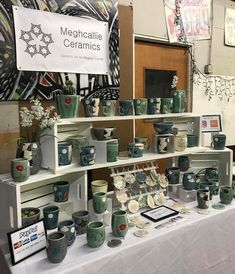 there are many cups and bowls on display at this table with a sign that says mementoallie ceramics