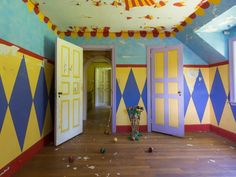 an empty room with blue, yellow and red painted walls